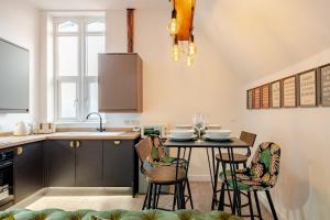 a kitchen with a table with chairs and a sink at Perfect Base for Work or Leisure Unique Two-Bed in Irlam