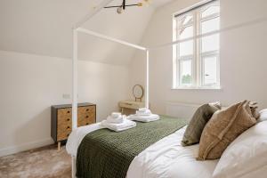 a white bedroom with a bed and a window at Perfect Base for Work or Leisure Unique Two-Bed in Irlam