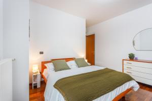 une chambre blanche avec un lit et une commode dans l'établissement Parking & Free WiFi - Functional apartment, à Modène