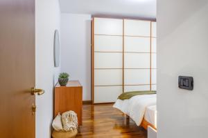 une chambre avec un lit et une porte coulissante en verre dans l'établissement Parking & Free WiFi - Functional apartment, à Modène 24 autres photos