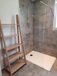 Un baño con ducha con puerta de cristal en Gîte avec salle de jeux, en Montfarville
