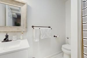 bagno bianco con servizi igienici e specchio di Casa Amarilla ad Arden Altre 16 foto