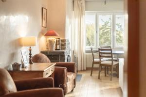 a living room with a couch and chairs and a table at Alpine Sunset l Attique l Golf l By CosyHome in Crans-Montana