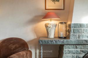a lamp on a table next to a brick fireplace at Alpine Sunset l Attique l Golf l By CosyHome in Crans-Montana
