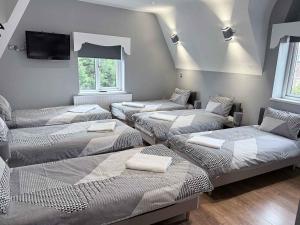 a room with four beds and a tv on the wall at Twelfth Man Accommodation part of The Twelfth Man Public House in Liverpool