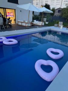 a swimming pool with two inflatable tubes in the water at Luxus Villa Hannover Messe in Hannover