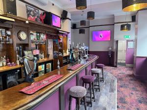 a bar in a pub with purple stools at Twelfth Man Accommodation part of The Twelfth Man Public House in Liverpool