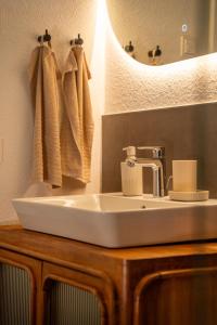 une salle de bains avec un lavabo blanc et un miroir dans l'établissement Riversidesuite-Tuebingen, à Tübingen 21 autres photos