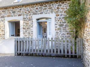 a wooden fence in front of a stone house at Holiday Home Le Nid de Cancale by Interhome in Cancale