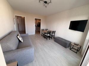 ein Wohnzimmer mit Sofa und Tisch in der Unterkunft Appart T2, Balcon, Calme, 800m Plage de La Baule in Le Pouliguen