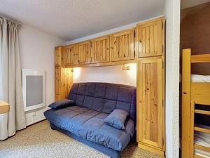 un canapé bleu dans une chambre avec un lit superposé dans l'établissement Studio Résidence des Montagnes by Interhome, à Bellevaux