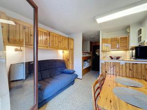 un salon avec un canapé bleu et une table dans l'établissement Studio Résidence des Montagnes by Interhome, à Bellevaux 13 autres photos