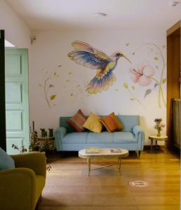 Una sala de estar con un mural de pájaros en la pared. en Usgar San Pedro Boutique, en Cusco