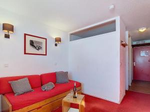 a living room with a red couch in a room at Studio Les Olympiades-23 by Interhome in Val Thorens