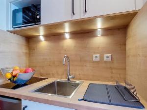 a kitchen with a sink and a bowl of fruit at Studio Les Olympiades-23 by Interhome in Val Thorens