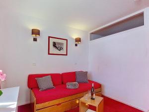 a living room with a red couch in a room at Studio Les Olympiades-23 by Interhome in Val Thorens