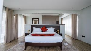 a bedroom with a large white bed with red pillows at The 67 Escape, Elementaita in Gilgil +16 photos