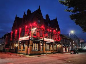 a large brick building with red lights on it at Twelfth Man Accommodation part of The Twelfth Man Public House in Liverpool