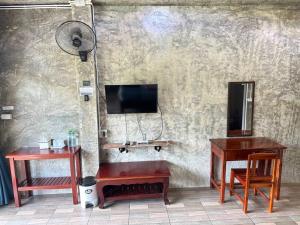 ein Raum mit zwei Tischen und einem Fernseher an der Wand in der Unterkunft pilokhillhouse บ้านอีต่องเหมืองปิล็อก in Ban Pilok Khi + 7 Fotos