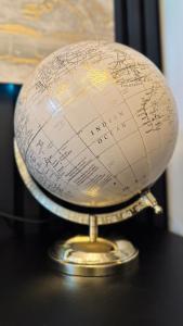 a gold terrestrial globe on a black table at Irenic Luxury Rentals in Coventry