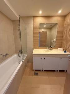 a bathroom with a tub and a sink and a mirror at Millo Apartament in Bucharest