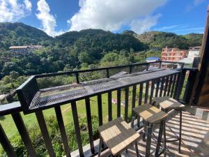 einen Balkon mit 2 Stühlen und Bergblick in der Unterkunft pilokhillhouse บ้านอีต่องเหมืองปิล็อก in Ban Pilok Khi