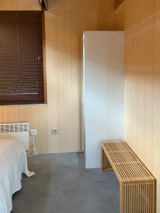 une chambre avec un lit et un mur en bois dans l'établissement Bamboo House, à Boyl