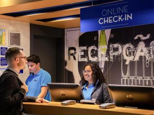 a group of people sitting at a table with laptops at ibis budget SP Frei Caneca in Sao Paulo