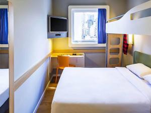 a small room with a bed and a tv at ibis budget SP Frei Caneca in Sao Paulo