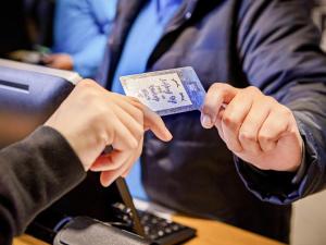 a person holding a credit card in front of a laptop at ibis budget SP Frei Caneca in Sao Paulo