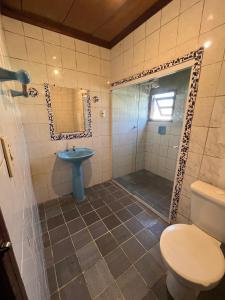 a bathroom with a shower and a toilet and a sink at Hostel da Luna in Paraty