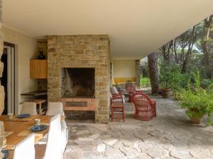 d'une terrasse avec une cheminée en pierre, des chaises et une table. dans l'établissement Holiday Home Engel by Interhome, à Casa Mora