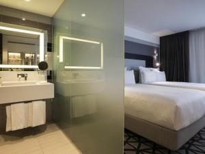 a hotel room with a bed and a sink at Pullman Sydney Airport in Sydney
