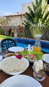 une table avec des plaques blanches de nourriture dans l'établissement Casa Monã - Praia de Tatuamunha - Serviços Inclusos, à Porto de Pedras 24 autres photos