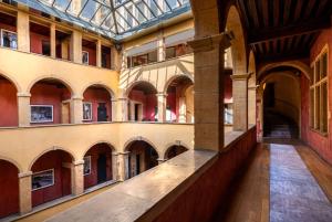 an empty hallway in a building with a glass ceiling at Cour des Loges Lyon, A Radisson Collection Hotel in Lyon