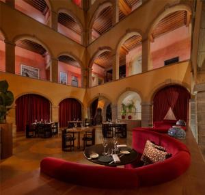 a restaurant with red chairs and tables in a building at Cour des Loges Lyon, A Radisson Collection Hotel in Lyon