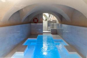 a swimming pool with blue water in a building at Cour des Loges Lyon, A Radisson Collection Hotel in Lyon
