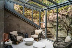 ein Glashaus mit zwei Stühlen und einer Treppe in der Unterkunft Cour des Loges Lyon, A Radisson Collection Hotel in Lyon