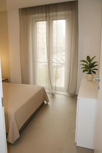 a bedroom with a bed and a window with a plant at Al GrattacieloTrenta in Verona