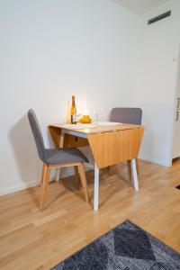 ein Esstisch mit zwei Stühlen und einem Weinglas in der Unterkunft Fully Equipped Studio in Prime Linné and Haga in Göteborg