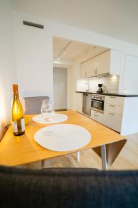 Eine Küche mit einem Holztisch, auf dem eine Flasche und ein Weinglas stehen. in der Unterkunft Fully Equipped Studio in Prime Linné and Haga in Göteborg