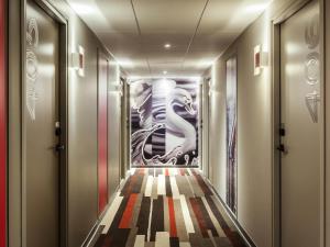 einen Flur mit einem Gemälde an der Wand in der Unterkunft ibis Saint Quentin en Yvelines - Vélodrome in Montigny-le-Bretonneux + 85 Fotos