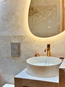 a bathroom with a sink and a mirror at Ermou 18 Central Cozy Apartment in Athens +8 photos