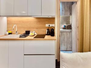 a kitchen with white cabinets and a sink at Ermou 18 Central Cozy Apartment in Athens