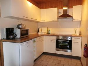 Una cocina con gabinetes blancos y un microondas. en Appartement Murtalblick In Pöls, en Pöls