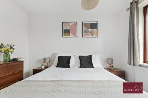 a white bedroom with a white bed with two night stands at Hitchin - Millstream - 2 Bedroom Coach House in Ickleford