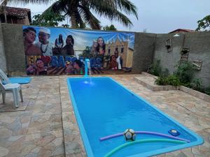 a pool with a water fountain in front of a billboard at Recanto Barcelos de Mel com piscina e churrasqueira in Camamu