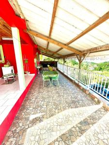 a patio with a table and chairs on a red wall at Maison de charme au Robert avec spa et vue sur mer in Le Robert +14 photos