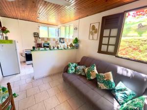 a living room with a couch and a kitchen at Maison de charme au Robert avec spa et vue sur mer in Le Robert