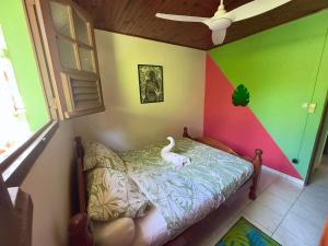 a room with a bed with a swan on it at Maison de charme au Robert avec spa et vue sur mer in Le Robert